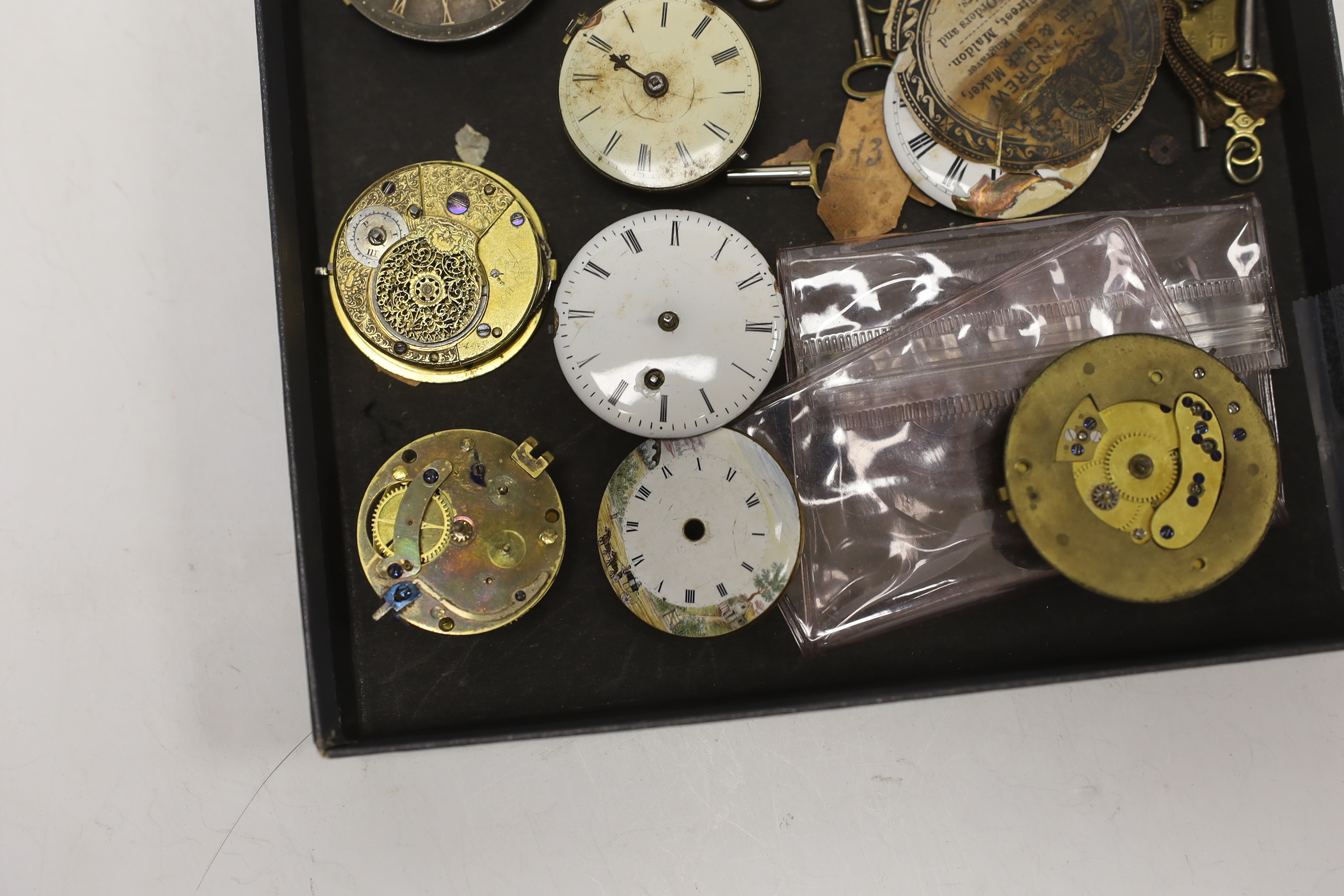 A small quantity of pocket watch accessories, including movements, dials and watch keys.